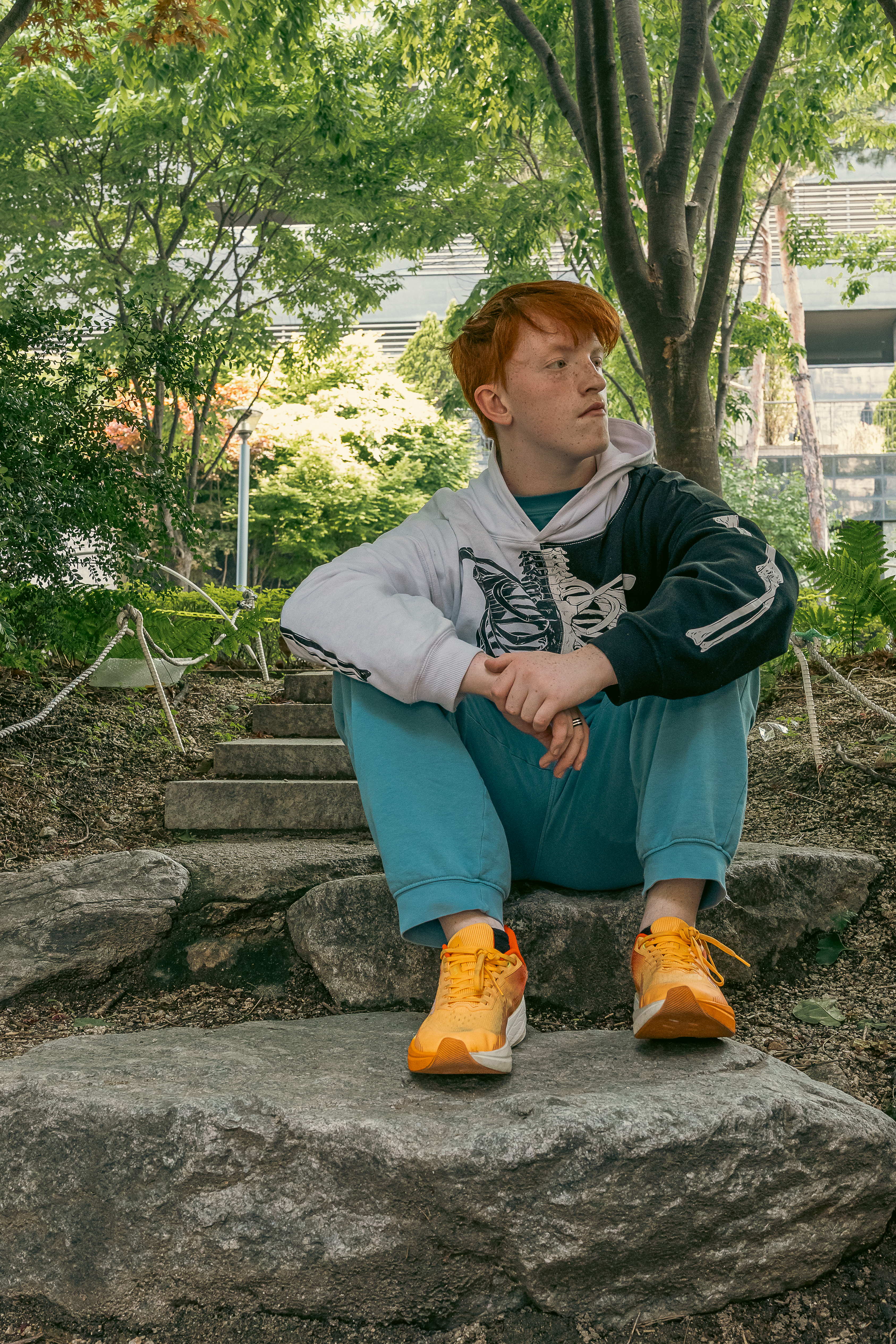 Kendall in hoodie sitting on rocks
